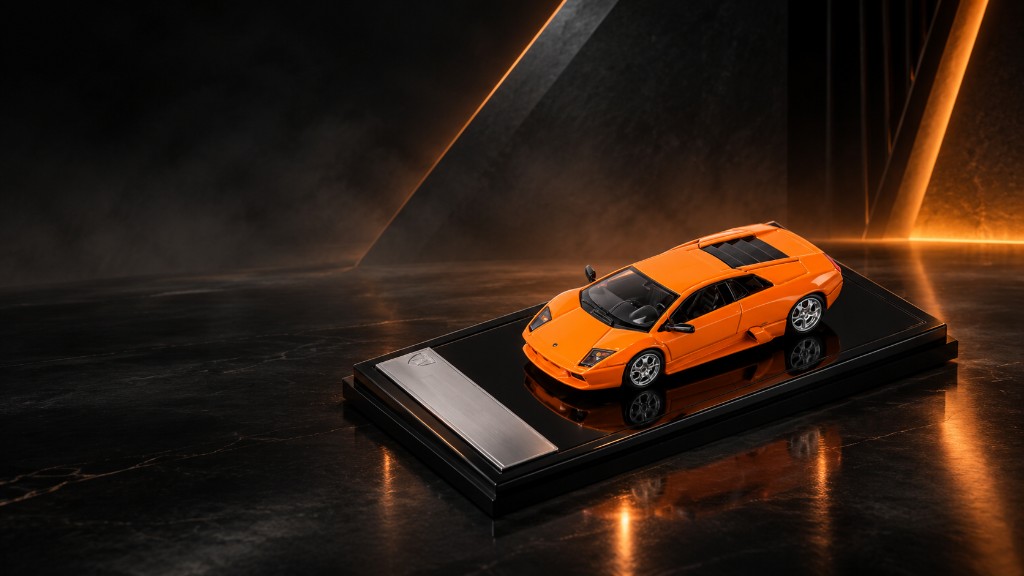 Orange Lamborghini Murciélago on a black plinth in a dark showroom